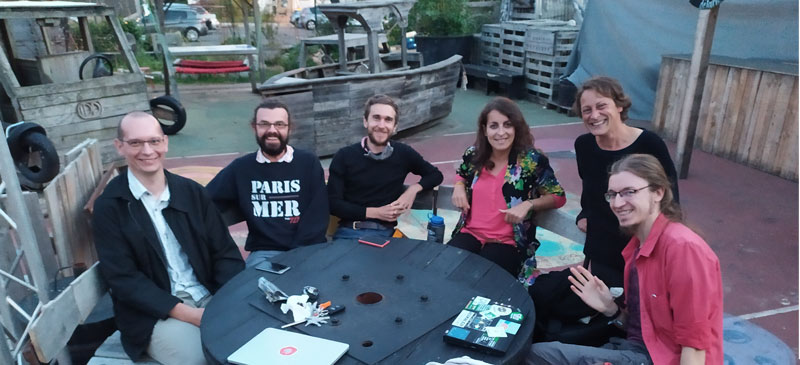 un groupe de personnes assises autour d'une table, souriant à l'objectif